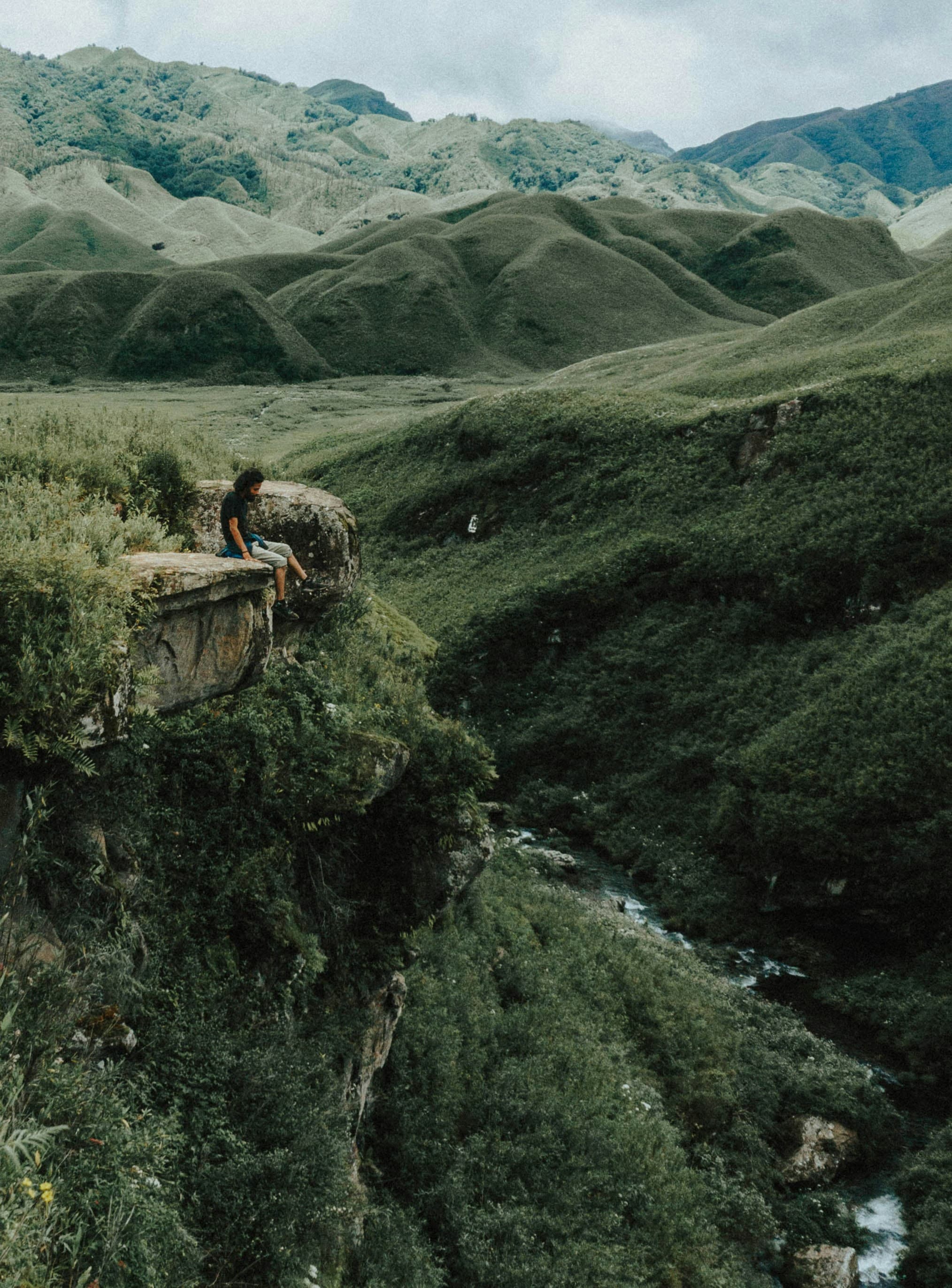 Trekker overlooking a stream on the Dzukou Valley floor