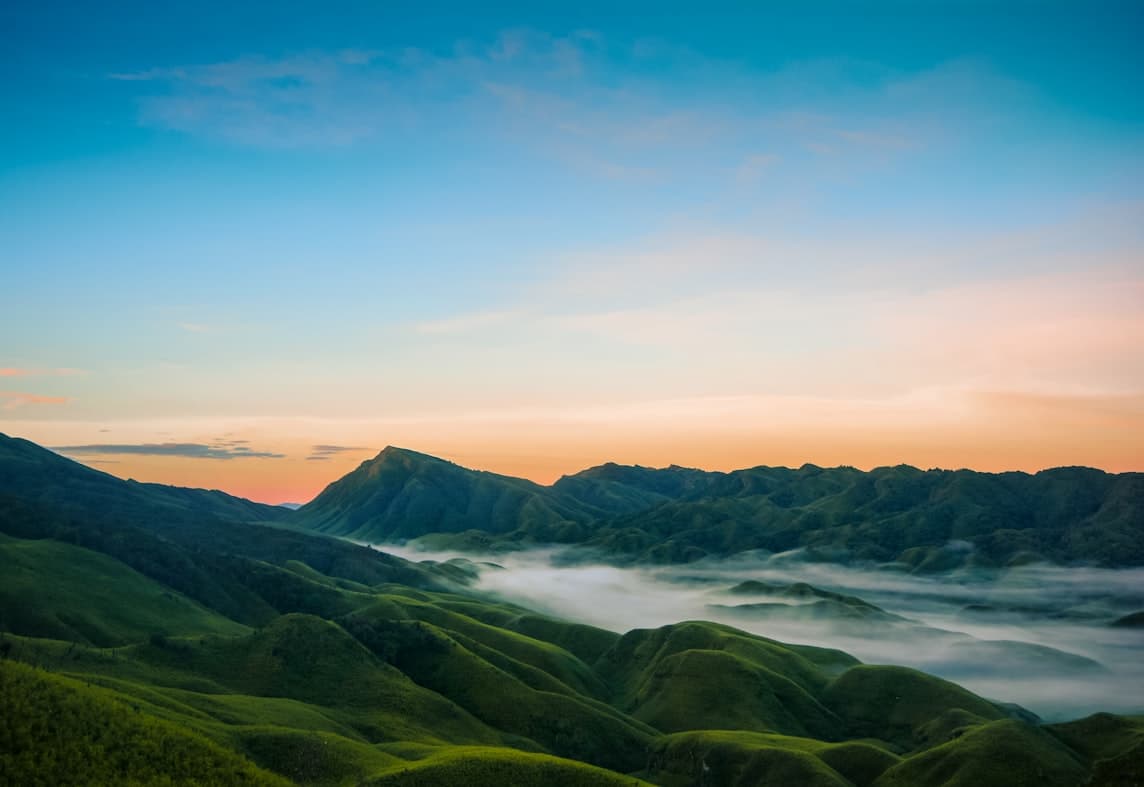 Sunrise and mist over the rolling hills of Dzukou Valley